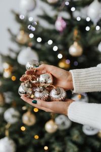 Kaboompics - Woman in a white Christmas sweater holds bunch of baubles