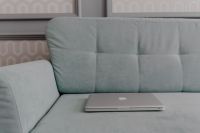 Kaboompics - MacBook laptop lying on mint couch