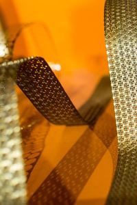 Kaboompics - Bended golden metal on an orange background