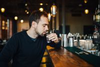Kaboompics - Handsome young man drinking vodka at the bar
