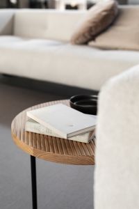Wooden fluted table - books - light beige sofa - oak - boucle