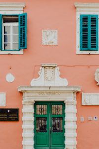 Pastel pink building with green doors and turquoise shutters, Rovinj, Croatia